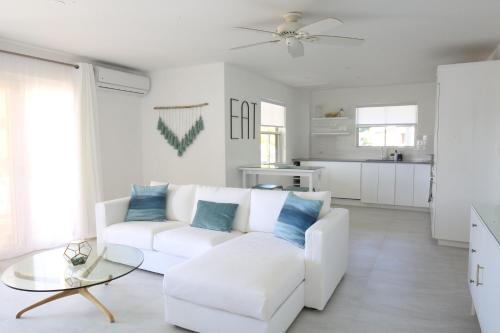 - un salon blanc avec un canapé blanc et des oreillers bleus dans l'établissement Sea Glass Villa - Spacious 3 Bed / 2 Bath (Lantana 39), à Saint James