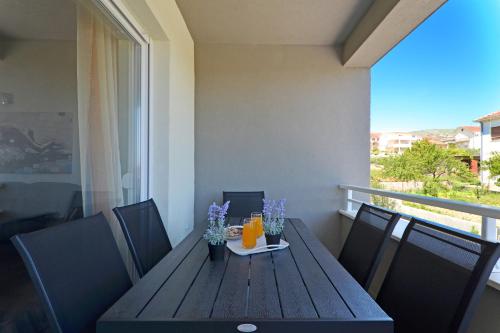 a wooden table with drinks and flowers on a balcony at sunshine in Trogir