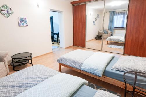 Un dormitorio con dos camas y un espejo. en Apartament Bardzo Popularny, en Bolesławiec