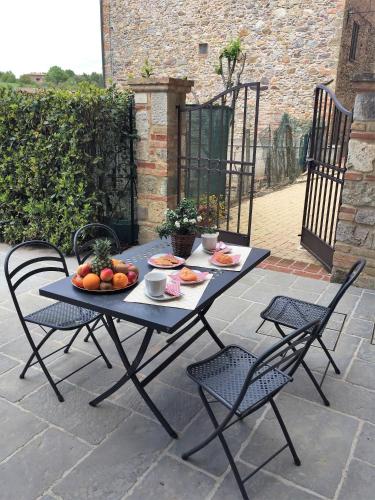 a table and chairs with a plate of fruit on it at Casa vacanza vicolo degli orti in Monticiano
