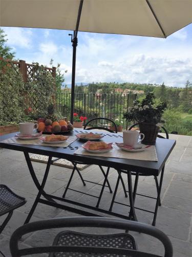 a table with plates of food on it with an umbrella at Casa vacanza vicolo degli orti in Monticiano