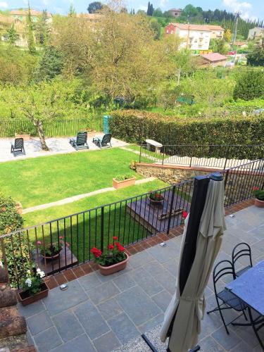 a fence with an umbrella on a patio at Casa vacanza vicolo degli orti in Monticiano