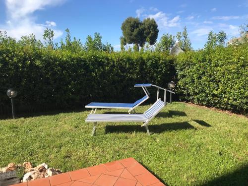 stół piknikowy i ławka w trawie w obiekcie Casavacanze estate 2 w mieście San Benedetto del Tronto