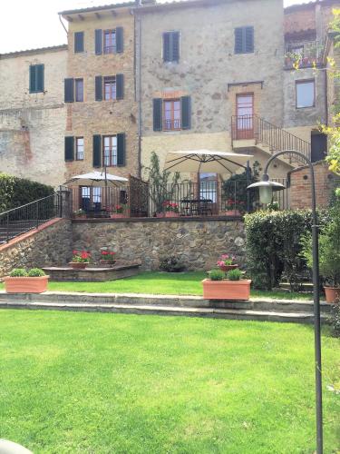 a large stone building with a green yard at Casa vacanza vicolo degli orti in Monticiano