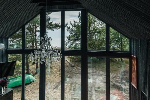 a chandelier is hanging in a room with windows at Jūras Krasti Harmonija in Jūrmalciems