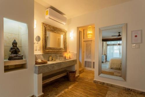 a bathroom with a sink and a mirror at Lotus Beach Hotel - Adults Only in Isla Mujeres