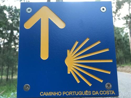 a blue sign with an arrow and a sun on it at Vasco da Gama in Póvoa de Varzim