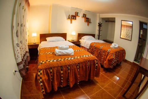 two beds in a hotel room with towels on them at Miski Warak in Chachapoyas