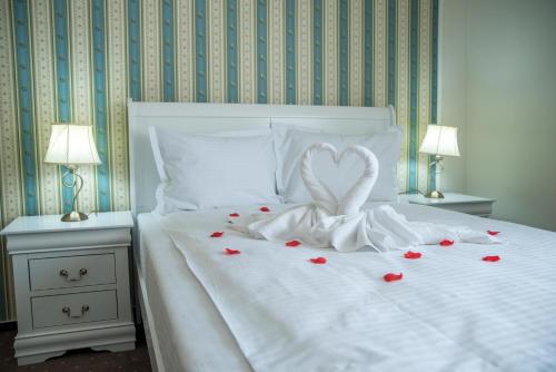 a white bed with a heart made out of roses at Select House in Sibiu