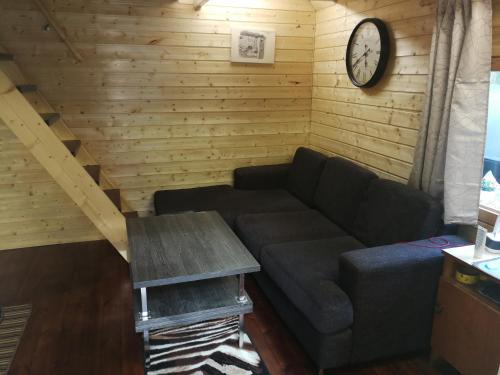a living room with a couch and a clock on the wall at Ainja Puhkemaja in Viljandi