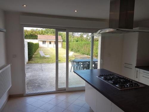 - une cuisine avec vue sur un patio équipé d'une cuisinière dans l'établissement Maison Napoléon, à Wimille