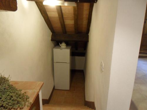a small refrigerator in a room with a ceiling at Casa vacanza vicolo degli orti in Monticiano