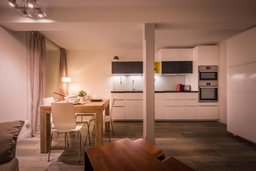 a kitchen and dining room with white cabinets and a table at Dependance Ost in Interlaken