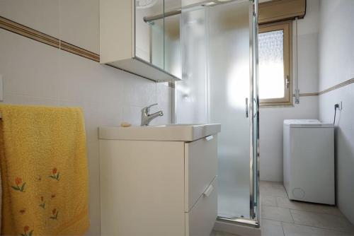 a white bathroom with a sink and a shower at Zibi&Bibbo in Marsala