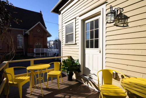 a deck with yellow chairs and a table and chairs at Nest Hudson in Hudson