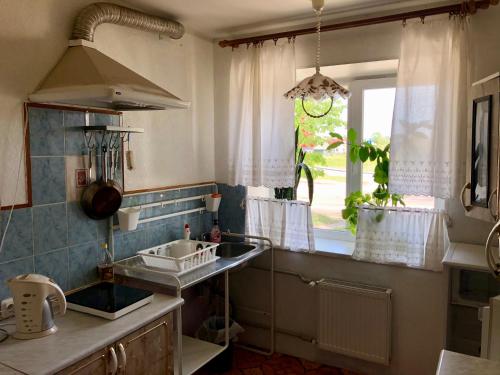 kuchnia ze zlewem i oknem w obiekcie Mājīgs dzīvoklis Salacgrīvā w mieście Salacgrīva