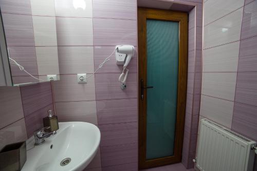 a bathroom with a sink and a phone on the wall at Angela in Polovragi