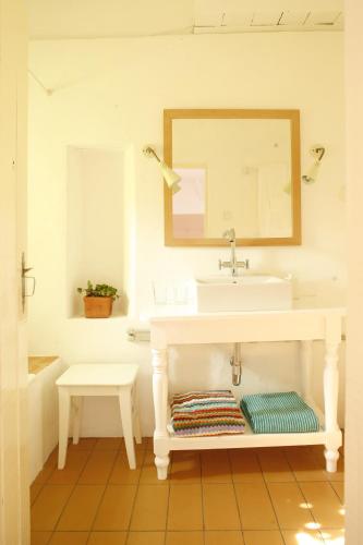 a bathroom with a sink and a mirror at Herdade da Matinha Country House & Restaurant in Cercal