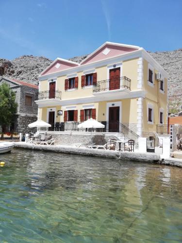 a house on the water next to a body of water at Perla di Mare in Symi