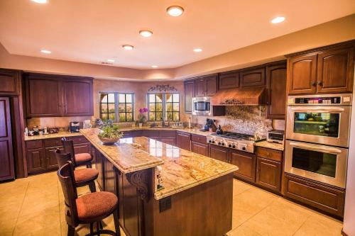 a large kitchen with wooden cabinets and a large island at Aterno Estate & Vineyard, Main House & Guest House in Templeton