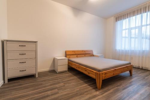 - une chambre avec un lit, une commode et une fenêtre dans l'établissement Old Port, à Liepāja