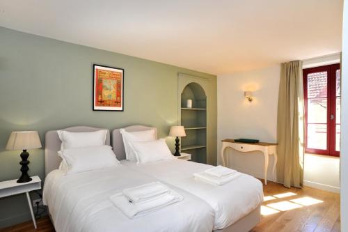 a bedroom with a white bed with two towels on it at Les Sarments in Santenay