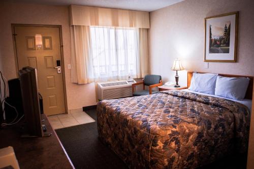 a hotel room with a bed and a window at Langley Hwy Hotel in Langley
