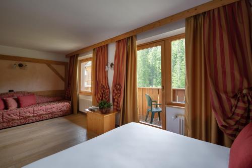 um quarto com uma cama e uma janela em Carlo Magno Hotel Spa Resort em Madonna di Campiglio