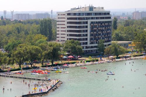 a group of people in the water at a beach at Club218 Wellness Apartments in Siófok