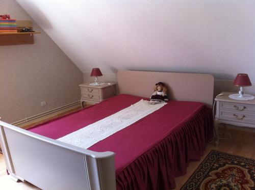 a doll sitting on a bed in a bedroom at GITE CHEZ JEAN PAUL in Fréland