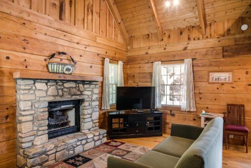 a living room with a stone fireplace and a tv at Boxwood Lodge Blowing Rock near Boone-University in Blowing Rock