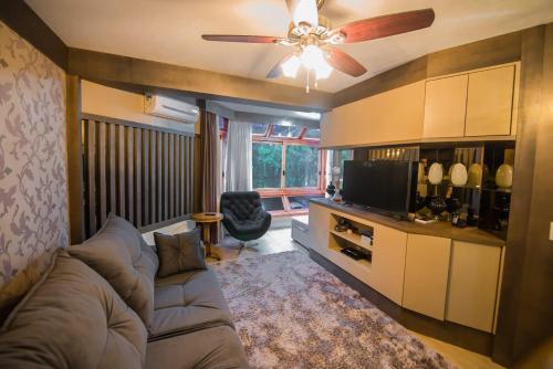 a living room with a couch and a ceiling fan at Flat no Hotel Wish Serrano Resort in Gramado