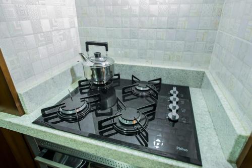 a stove top with a pot on top of it at Flat no Hotel Wish Serrano Resort in Gramado