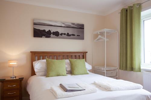 a bedroom with a bed with two books on it at Fàilte Mhòr in Fort William