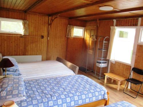 1 dormitorio con 1 cama en una habitación con paredes de madera en House of Quartz, en Goleen