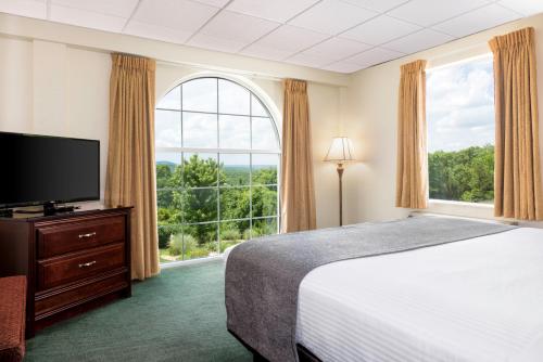 A bed or beds in a room at Savannah House Hotel