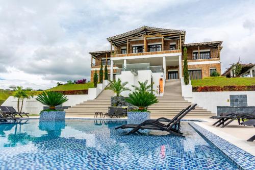 a villa with a swimming pool and a house at Hotel La Magdalena Adult Only in Guatapé