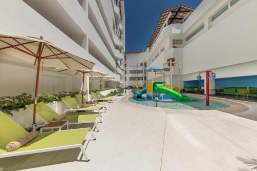 a pool at a resort with chairs and a slide at Grand Park Royal Puerto Vallarta - All Inclusive in Puerto Vallarta