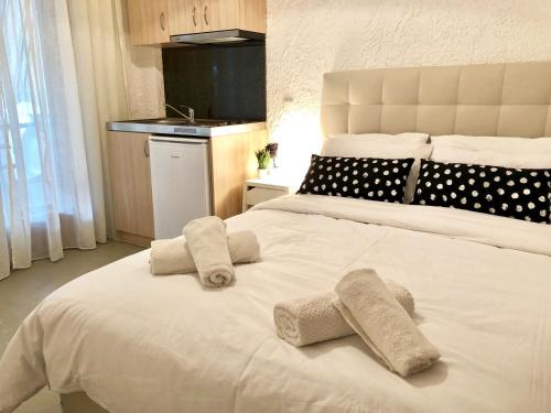 a bedroom with a large white bed with towels on it at Katerina apartments in Néos Pírgos