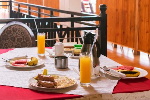 a table with two plates of food and orange juice at Easy View Hotel Mbarara in Mbarara