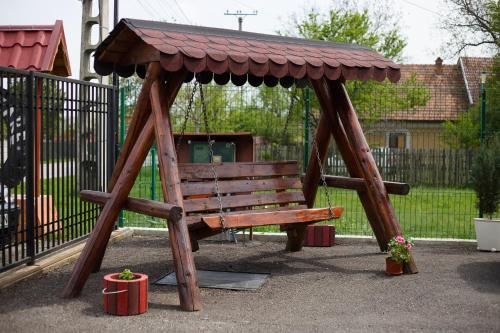 a wooden bench with a roof on a playground at Angela in Polovragi