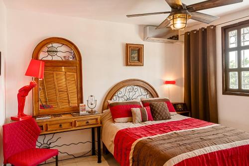 una camera con letto, scrivania e sedia rossa di Casa Blanca Boutique & Organic a Cancún