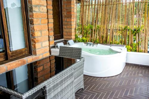 a bath tub sitting on a patio next to a window at Hotel La Magdalena Adult Only in Guatapé