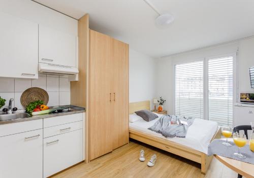 a small kitchen with a bed in a room at Swiss Star Tower - Self Check-In in Zürich