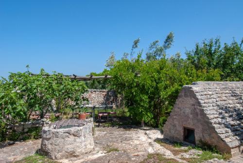 a garden with a stone building and trees at Casa Vacanze Riposo Del Vento in Cisternino