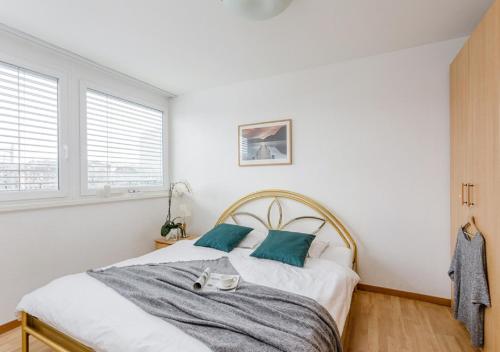 1 dormitorio blanco con 1 cama grande con almohadas azules en Swiss Star Tower - Self Check-In en Zúrich