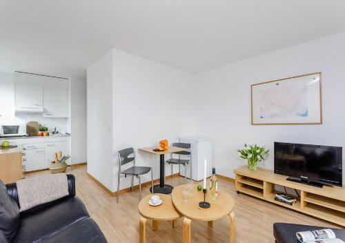 ein Wohnzimmer mit einem Sofa und einem Tisch in der Unterkunft Swiss Star Tower - Self Check-In in Zürich