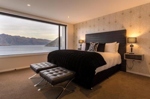une chambre avec un grand lit et une grande fenêtre dans l'établissement Fifteen by Amazing Accom, à Queenstown