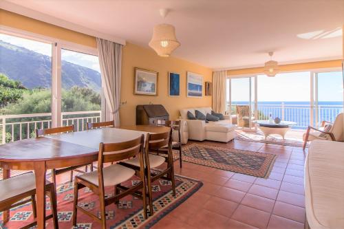 a living room with a table and chairs at Villa in protected space in front of the sea in Los Realejos