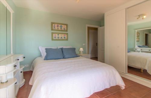 a bedroom with a white bed and a mirror at Villa in protected space in front of the sea in Los Realejos